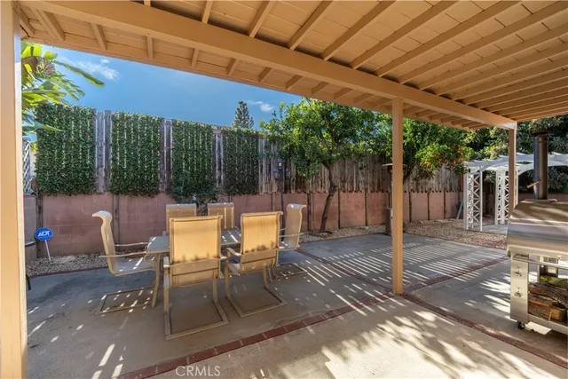 a view of a patio with table and chairs and floor to ceiling window with wooden floor