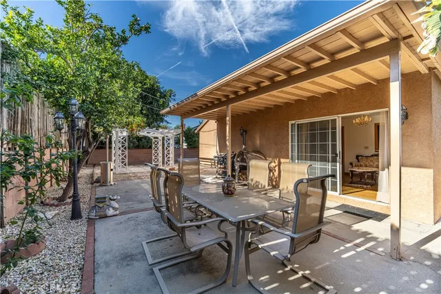 a view of a patio with table and chairs and potted plants