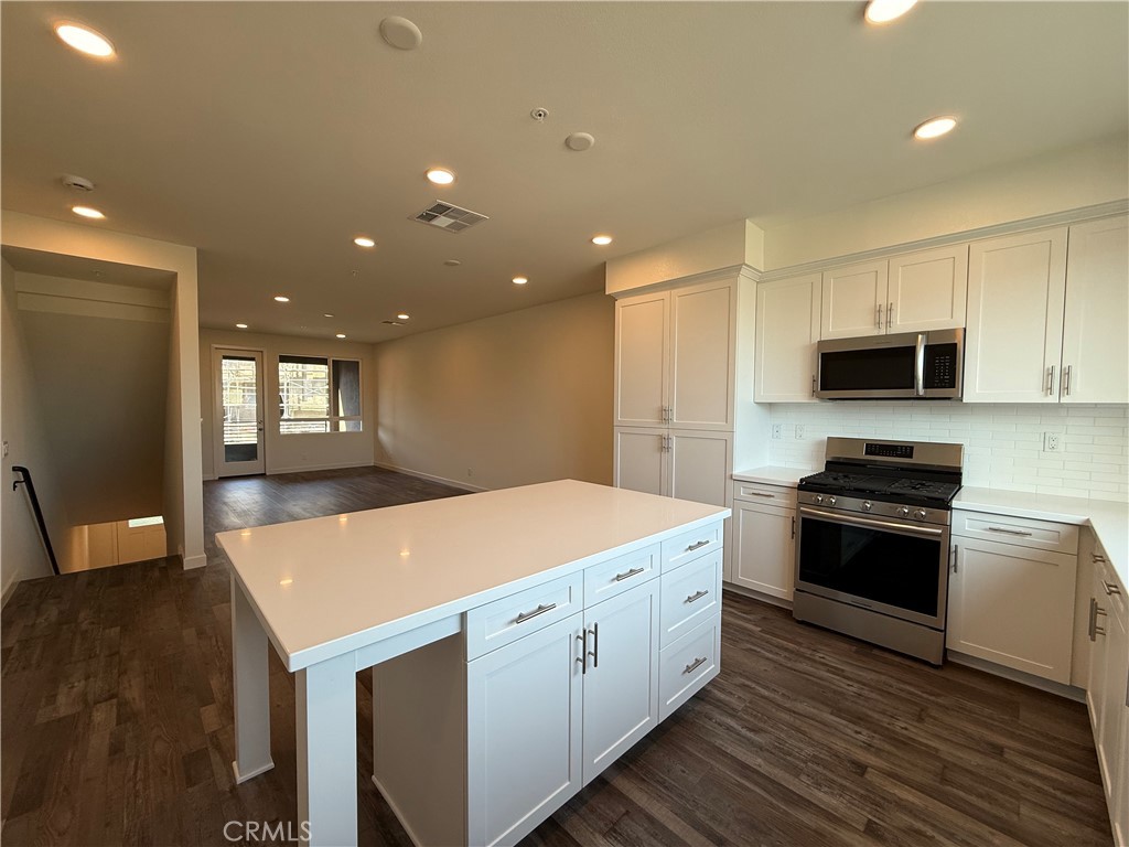78 Bigsby Drive Stanton, CA 90680 - Photo 3 of 9 a kitchen with stainless steel appliances granite countertop a sink stove and refrigerator