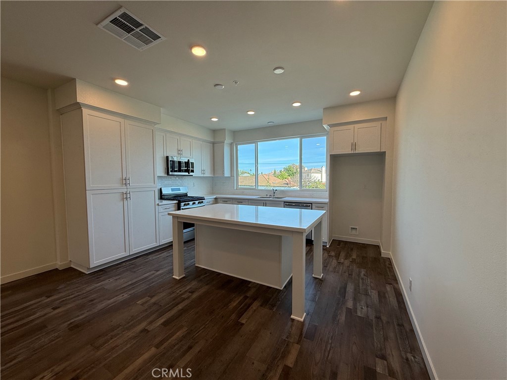 78 Bigsby Drive Stanton, CA 90680 - Photo 4 of 9 a kitchen with a refrigerator and white cabinets