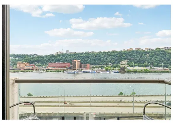 a view of balcony with a couple of cars parked in parking lot
