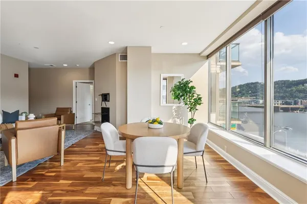 a living room with furniture kitchen view and a large window