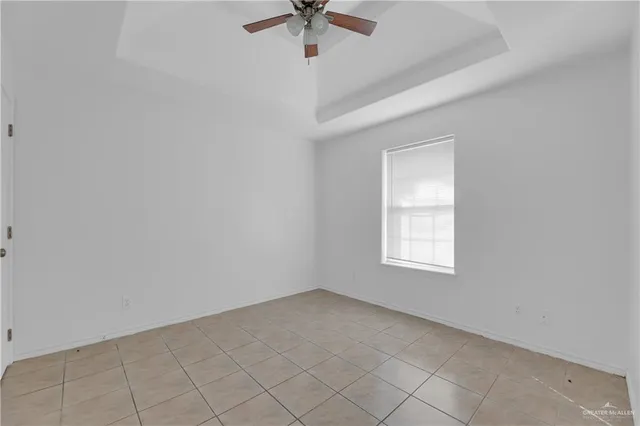 an empty room with a window and a ceiling fan