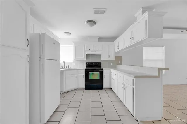 a kitchen with a refrigerator and a stove top oven