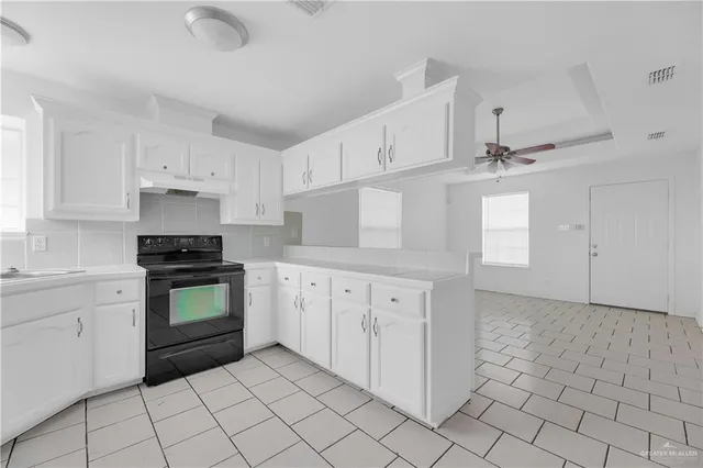 a kitchen with granite countertop white cabinets and appliances