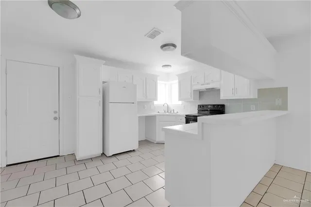 a kitchen with stainless steel appliances a refrigerator sink and white cabinets