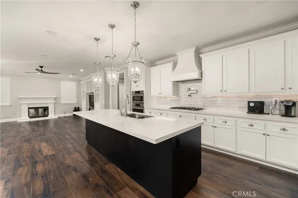 a kitchen with kitchen island granite countertop a sink stainless steel appliances and cabinets