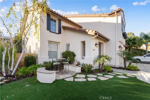 a front view of house with a garden and patio