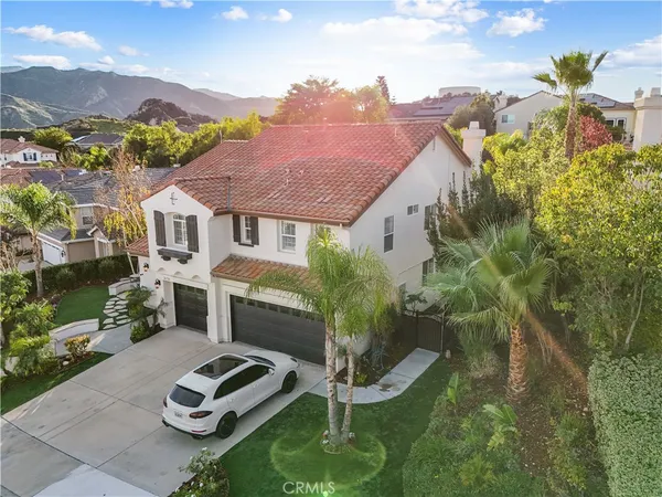 a aerial view of a house with garden space and a car park in front of it