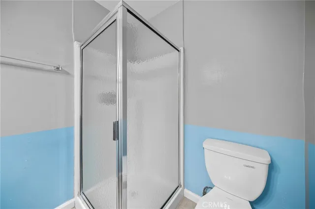 a bathroom with a toilet and a shower