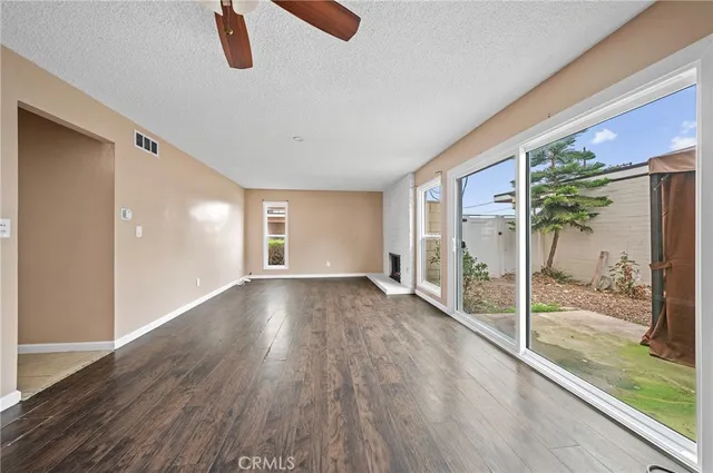 a view of a big room with wooden floor and windows