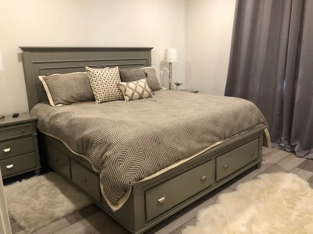 a large bed sitting in a bedroom next to a window