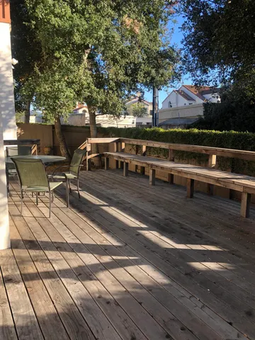 a view of a patio with dining table and chairs with wooden floor and fence