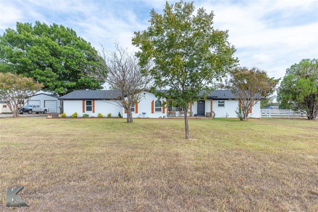 a front view of a house with a yard and trees