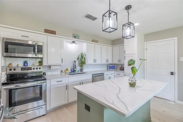 a kitchen with a sink a stove and cabinets