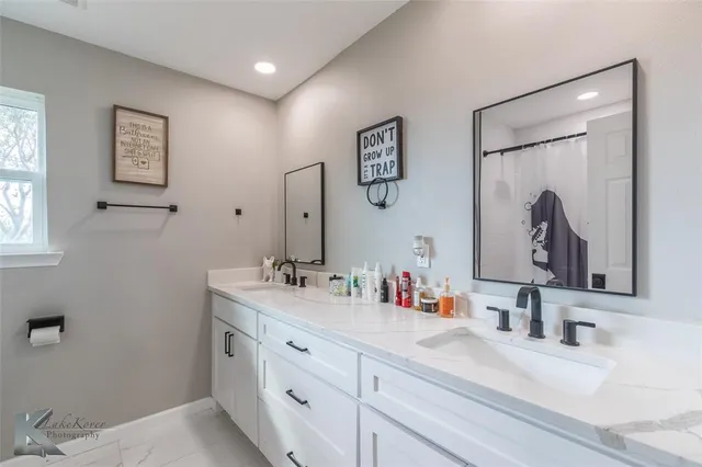 a bathroom with double vanity sinks a toilet and a mirror