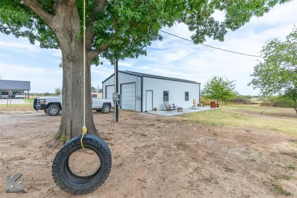 a backyard of house with table and chairs