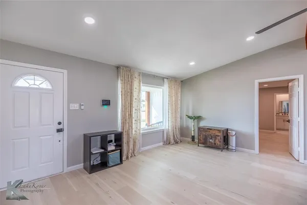 a view of empty room with wooden floor and windows