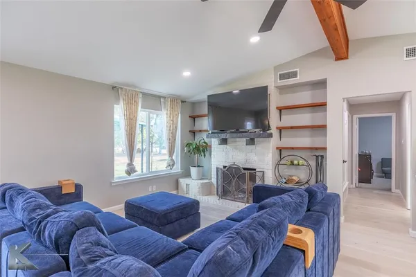 a living room with furniture a flat screen tv and a fireplace