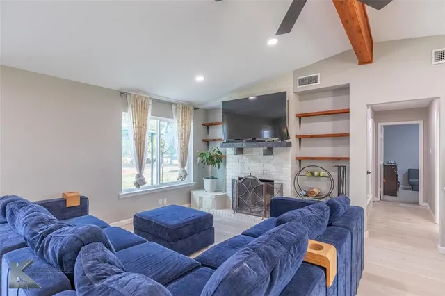 a living room with furniture a flat screen tv and a fireplace