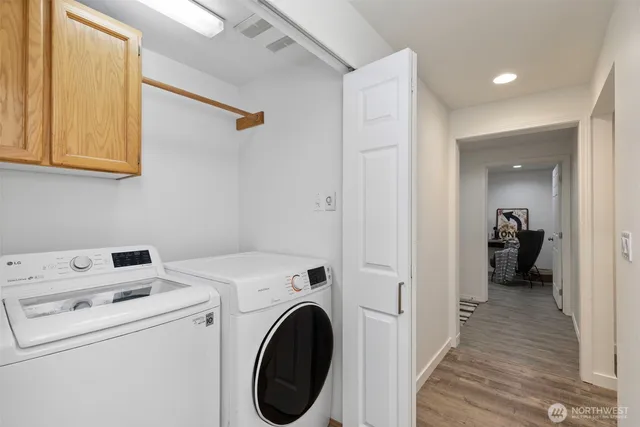 a view of a hallway with a room and wooden floor
