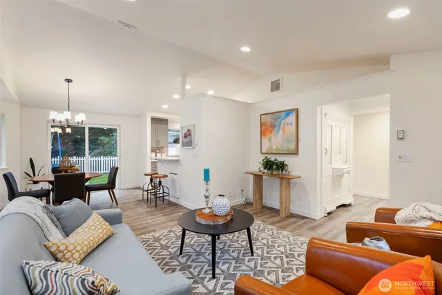 a dining room with furniture a chandelier and wooden floor
