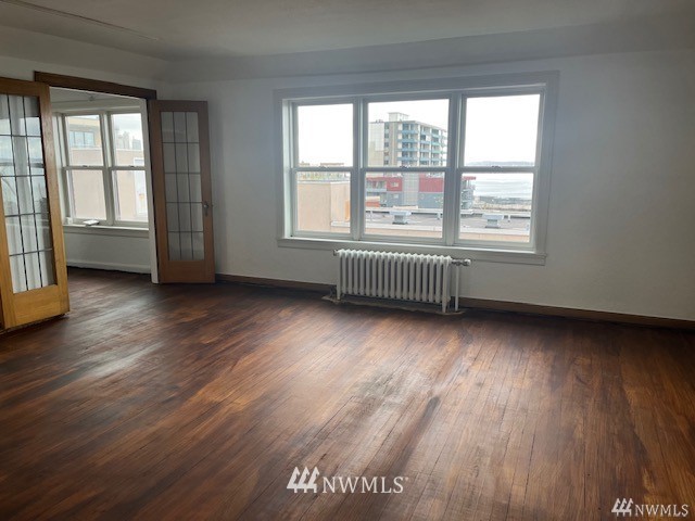519 West Roy Street, Unit 408 Seattle, WA 98119 - Photo 8 of 25 an empty room with wooden floor and windows