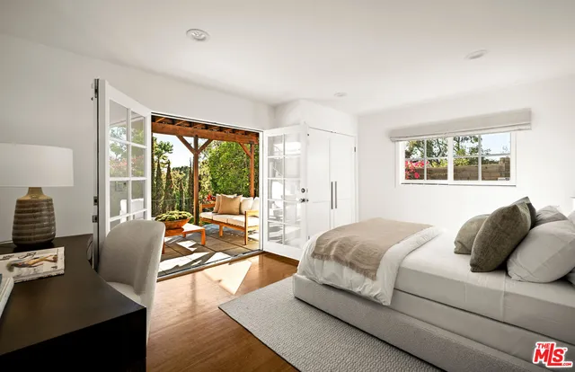 a spacious bedroom with a bed and glass window