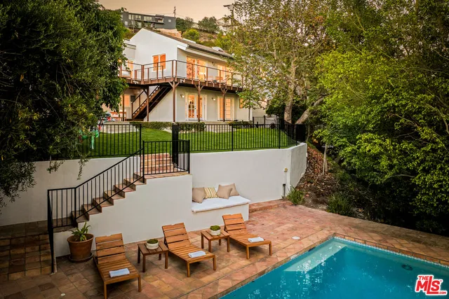 a roof deck with table and chairs and potted plants