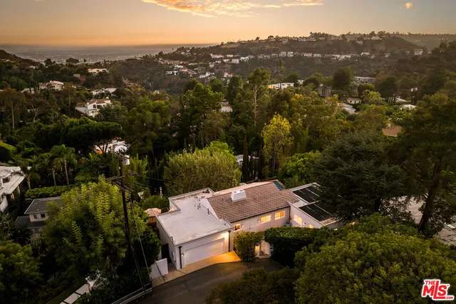 an aerial view of a house with a yard and lake view