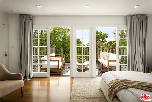 a bedroom with a large window and a balcony