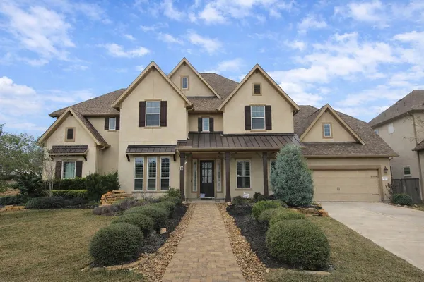 a front view of a house with yard and parking