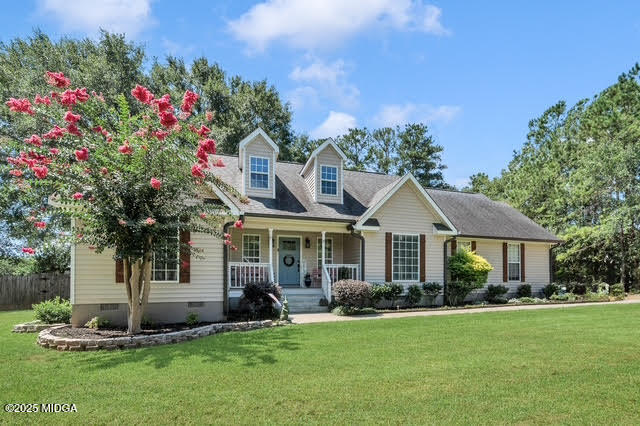 a front view of a house with a garden and trees