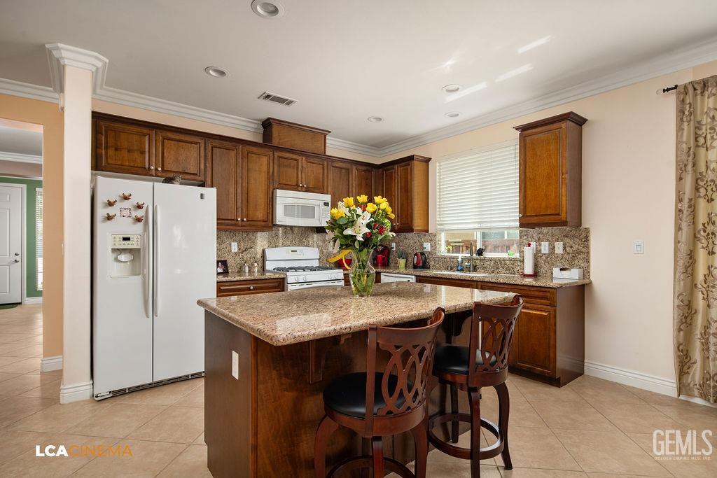 Undisclosed Address Bakersfield, CA 93306 - Photo 7 of 51 a kitchen with stainless steel appliances granite countertop a dining table chairs refrigerator and cabinets