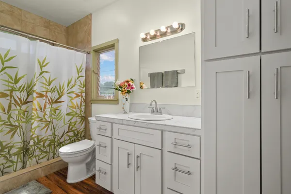 a bathroom with a granite countertop sink a toilet and a mirror