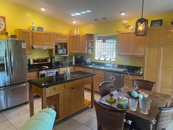 a kitchen with stainless steel appliances kitchen island granite countertop a sink and cabinets