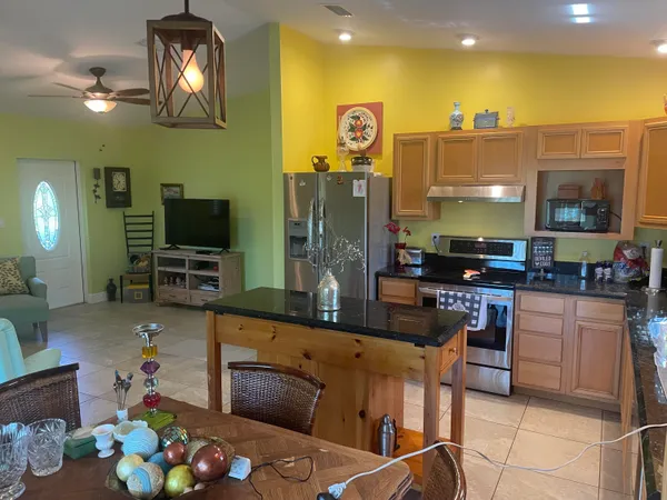 a kitchen with stainless steel appliances granite countertop a sink refrigerator and cabinets