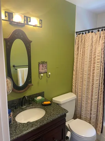 a bathroom with a toilet mirror vanity and vanity