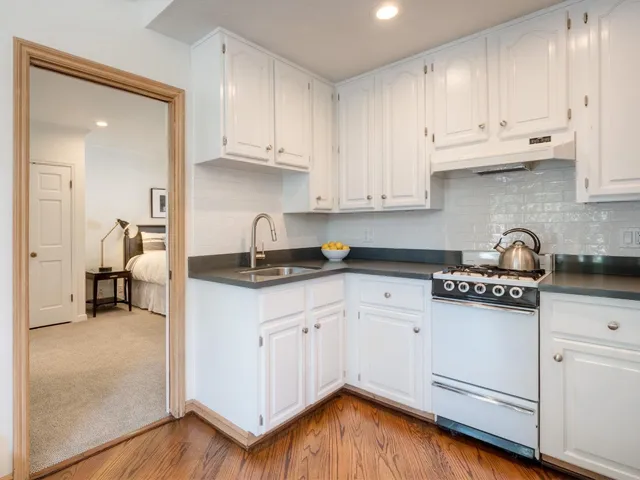 a kitchen with granite countertop wooden cabinets and white appliances