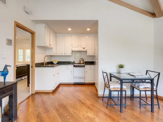 a kitchen with granite countertop white cabinets and appliances
