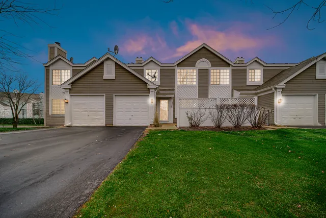 a front view of a house with a garden and yard
