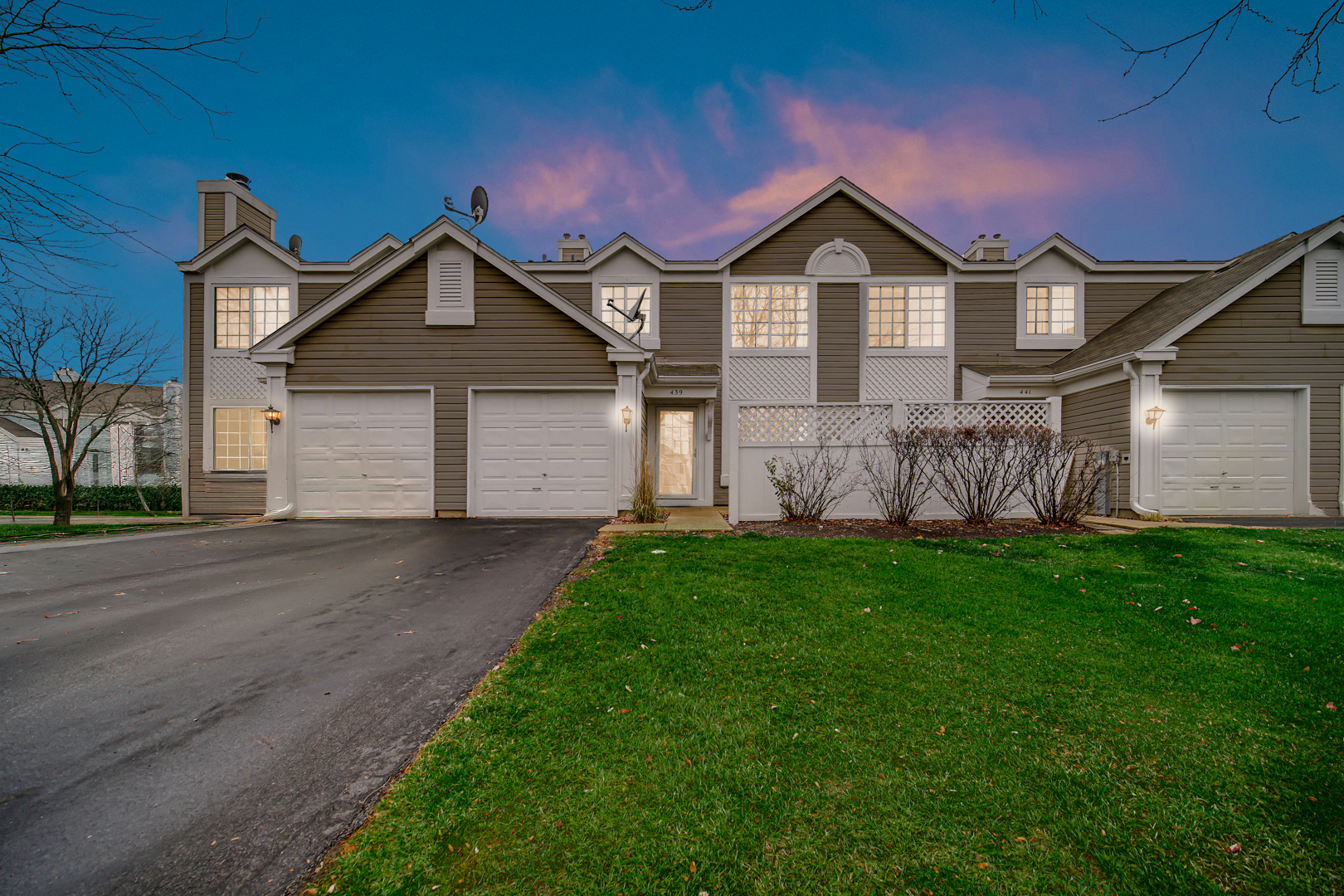 a front view of a house with a garden and yard