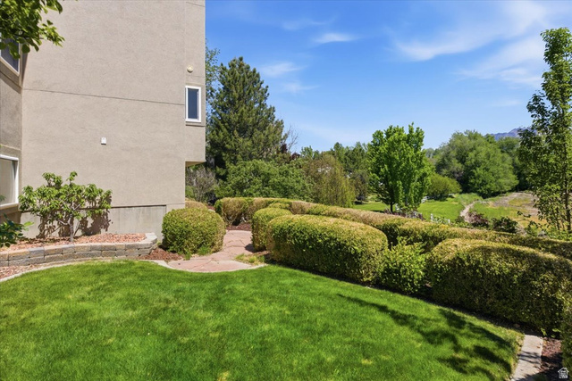 12317 Cypress Point Way Draper, UT 84020 - Photo 40 of 41 Stucco exterior with a stone retaining wall, offering a manicured lawn and mature hedges