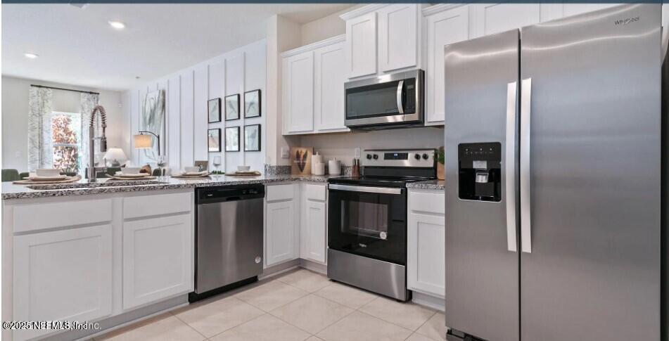 a kitchen with stainless steel appliances granite countertop a refrigerator a stove top oven a sink and dishwasher