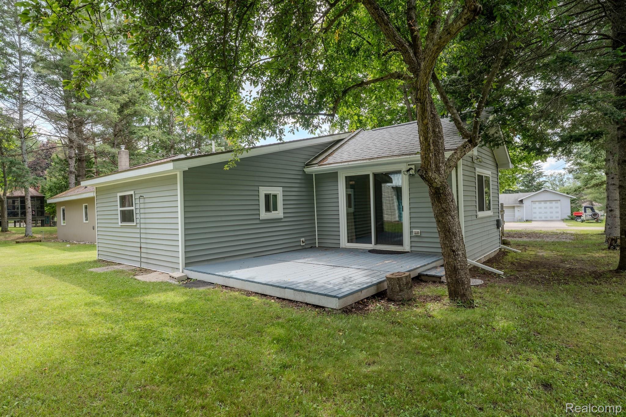 4350 Shrew Road Lincoln, MI 48742 - Photo 3 of 32 Rear exterior featuring gray horizontal siding, a gray painted deck, and a sliding glass door