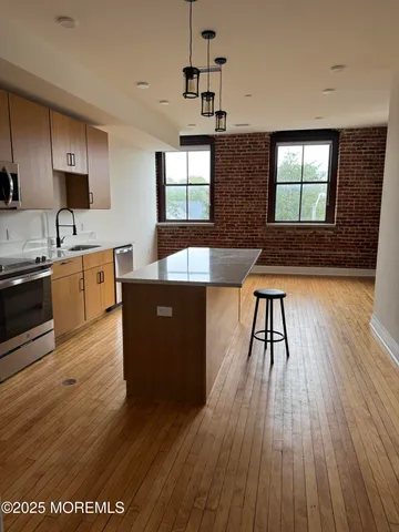 a kitchen with stainless steel appliances granite countertop wooden floors and sink
