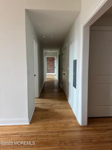 a view of a hallway with wooden floor