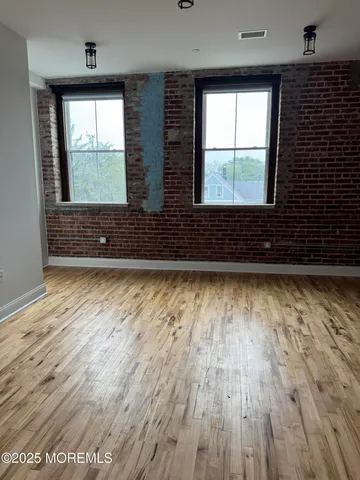 a view of a room with wooden floor and window