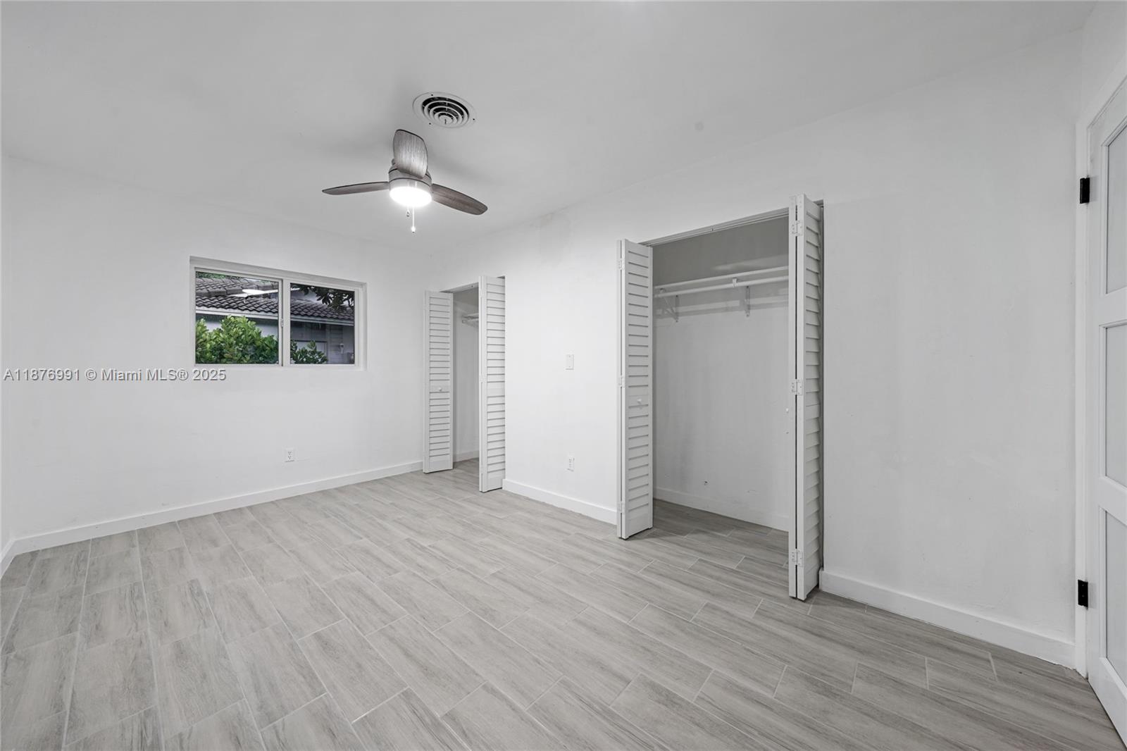 7516 Northwest 44th Court, Unit B Coral Springs, FL 33065 - Photo 11 of 26 an empty room with wooden floor ceiling fan and windows