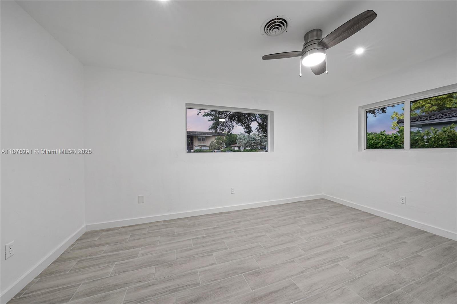 7516 Northwest 44th Court, Unit B Coral Springs, FL 33065 - Photo 15 of 26 an empty room with wooden floor and windows